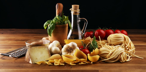 Pasta, vegetables, herbs and spices for Italian food on rustic table