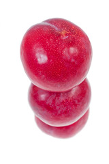 Pyramid of red plums isolated on a white background.