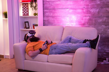 Male sitting on couch with virtual reality goggles
