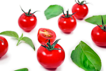 Ripe red tomatoes with basil leaves isolated on a white background.