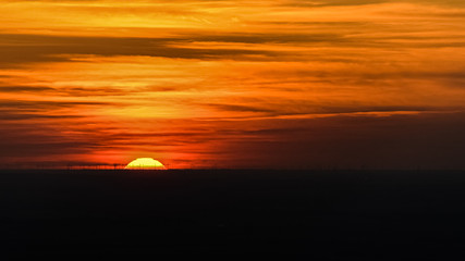 Fototapeta premium Couché de soleil sur champs d'eoliennes