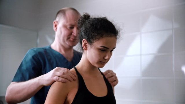 Chiropractic treatment - the doctor inspecting the young woman before the session