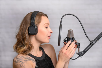 Recording a speech on a radio station, announcer, or singer, blogger works in the studio with a...