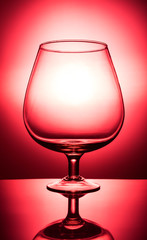 glass of red wine on red background