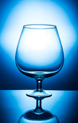 empty wine glass of water on blue background
