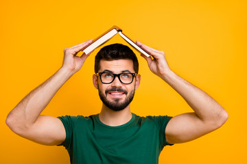 Close up photo of cheerful brunet hair guy put paper book above head look creative reading concept...