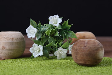 Dekorative Holzkugeln auf Tisch mit Kunstblume