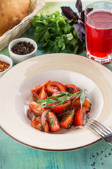 healthy appetizer fresh tomato salad in white bowl with red onion and estragon on blue wooden table