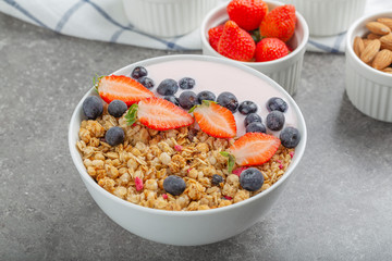 Granola with yogurt fresh strawberries and blueberries on a stone table. Healthy snack. The food for Breakfast. 