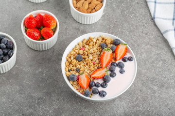 Granola with yogurt fresh strawberries and blueberries on a stone table. Healthy snack. The food for Breakfast. 