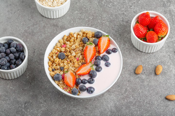Granola with yogurt fresh strawberries and blueberries on a stone table. Healthy snack. The food for Breakfast. Top view.