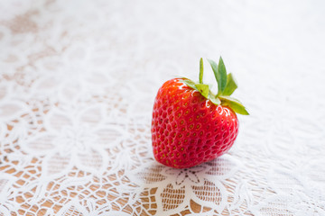 Organic fresh farm strawberries close up lying on a Lacy white tablecloth. Copy space