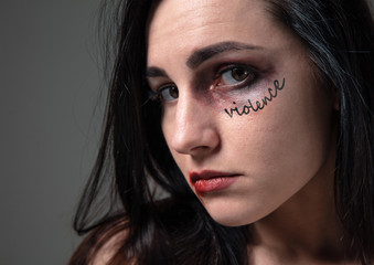 Woman in fear of domestic abuse, violence, concept of female rights. Brunette woman on grey...