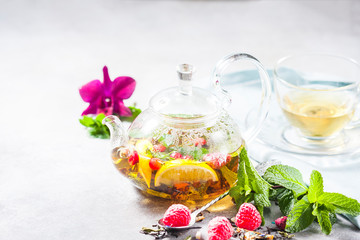 Hot herbal tea with lemon, raspberries and mint. Healthy lemon tea.