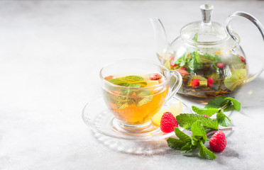 Hot herbal tea with lemon, raspberries and mint. Healthy lemon tea.