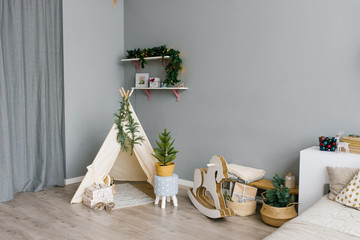 The interior of the children's room, decorated for Christmas and New Year. Wigwam, rocking horse, Christmas tree.