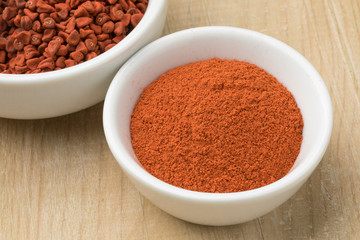  Bowl with dried Annatto seeds and a bowl with ground Annatto  powder