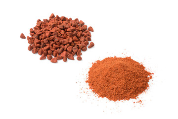 Heap of dried Annatto seeds and a heap of ground Annatto  powder