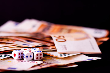 DICE AND MONEY ON BLACK BACKGROUND. TABLE SET WITH BETS