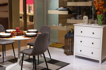 Beautiful served table with autumn leaves decorations and candle. Table served for autumn dinner in the living room.