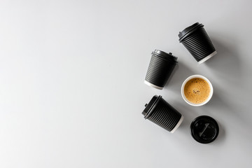 black paper cup and hot coffee on white table background