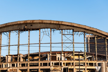 Demolition of the arena. Old metal frame of the building, destroyed walls.