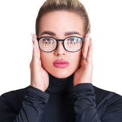 Woman with eye chart reflected in glasses.