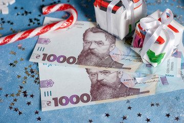 Ukrainian 1000 hryvnia on a blue background with stars, candy and gifts. The concept of buying...