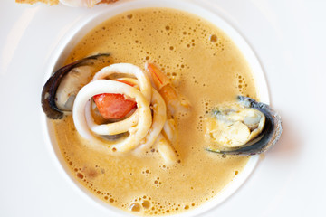 creamy seafood soup with mussels, squid, tomatoes, garlic and prawn