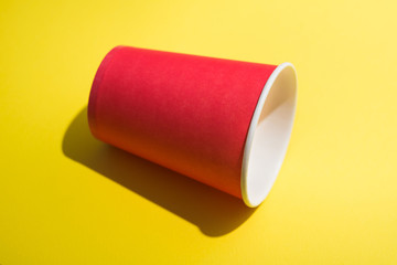 Red paper cup of coffee on a pastel background