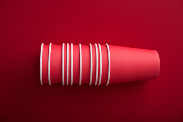 Red paper cup of coffee on a pastel background