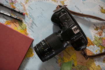Bodegón aventurero con cámara, mapa, y libro.
