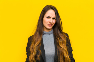 young pretty woman looking happy and friendly, smiling and winking an eye at you with a positive...
