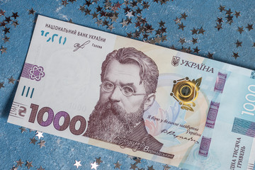 Ukrainian 1000 hryvnia on a blue background with stars. Portrait of Vladimir Ivanovich Vernadsky for 1000 hryvnias of the Ukrainian banknote of 2019. Close up.