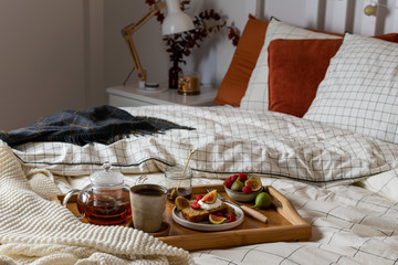 Breakfast in bed with pastry and fresh fruits, black tea