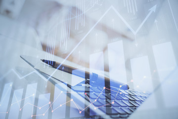 Forex Chart hologram on table with computer background. Multi exposure. Concept of financial markets.