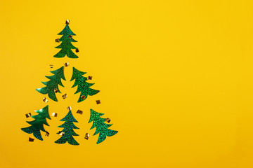Creative Christmas minimal mockup in trendy yellow with Christmas tree of six bright green holographic Christmas trees.