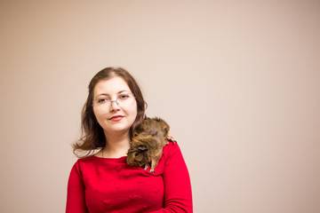 Young beautiful girl in glasses with her cute funny guinea pig