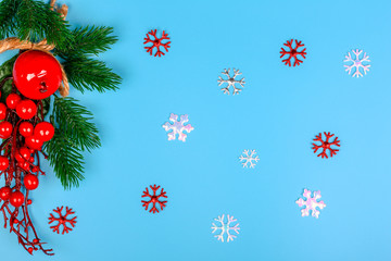 Christmas background. Spruce branch. Red berries. Snowflakes. Top view. Close-up.