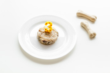 Birthday treat for puppy concept. Dog feed, candle in shape of number three, bones on white background