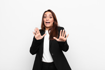 young pretty businesswoman feeling terrified, backing off and screaming in horror and panic,...