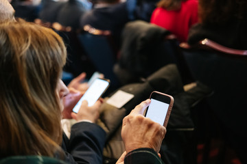 A woman uses the mobile phone in a congress