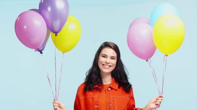 smiling girl with party balloons isolated on blue