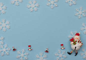 Christmas blue background with Christmas decorations and white snowflakes. New Year greeting card. Flat lay style. 