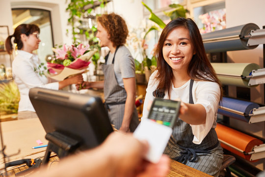 Kassiererin nimmt Kreditkarte zum Bezahlen