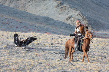 Eagle hunter catching his eagle mid-flight.