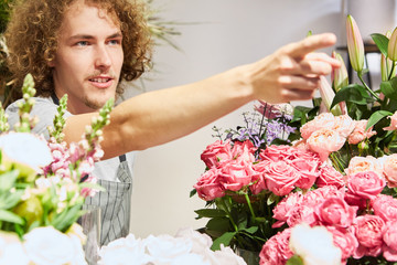 Obraz premium Florist als Verkäufer mit Sortiment an Blumen