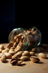 glass jar full of natural almonds with peel