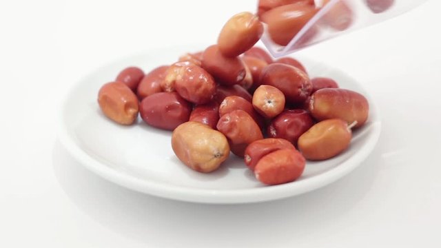 Oleaster spilling on a rotating plate on a white background