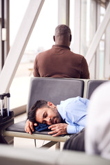 Businessman Sleeping On Seats In Airport Departure Lounge Because Of Delay
